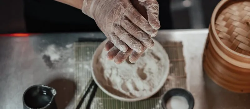 Chef préparant des aliments avec des gants d'hygiène en cuisine professionnelle